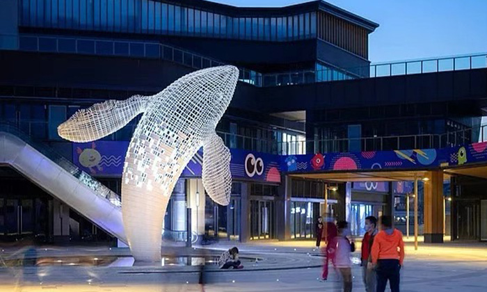 „Schimmernde Walskulptur aus Metall in der Skyline der Stadt“